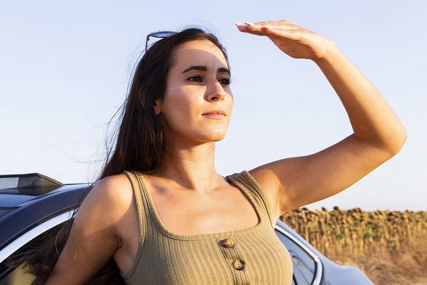 donna che ha gli occhi quasi chiusi grazie al sole. protezione solare