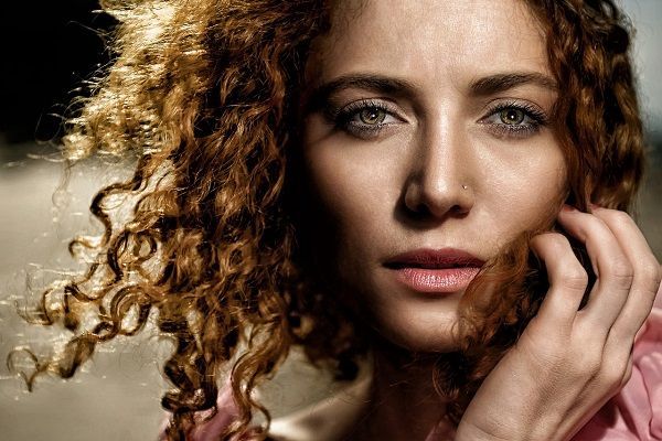 donna con occhi chiari e capelli ricci rossi