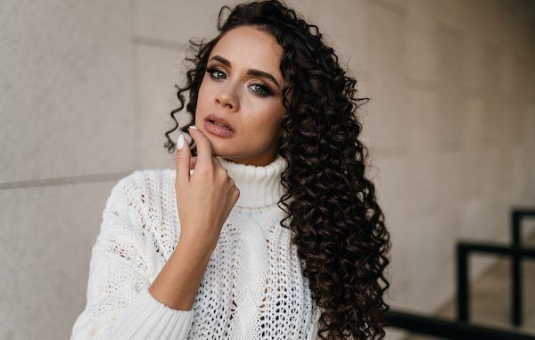 donna capelli ricci maglione bianco