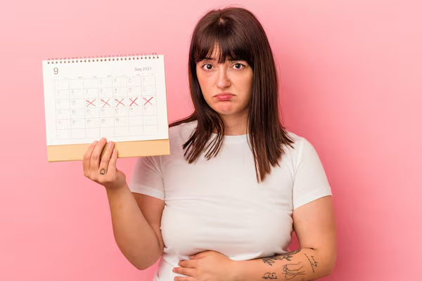 Donna con espressione di disagio che tiene in mano un calendario