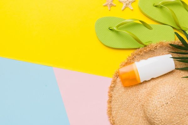 Concetto di vacanza estiva, cappello di paglia piatto, accessori da spiaggia e infradito vista dall'alto Spazio per il concetto di viaggio del testo