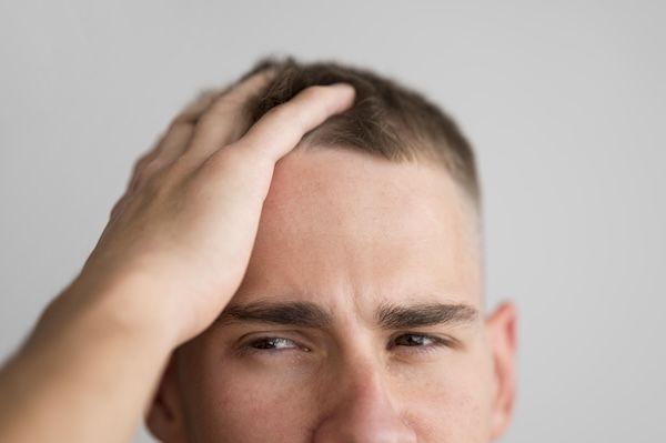 L'uomo si passa le dita tra i capelli