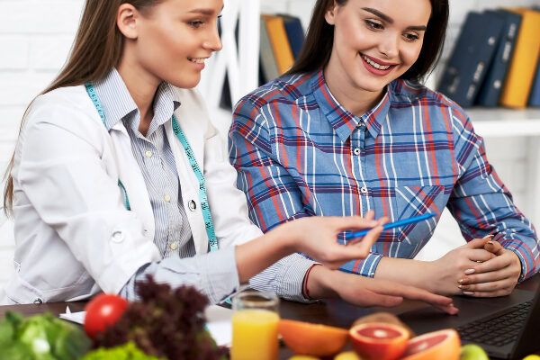 Nutrizionista che spiega al paziente che le sue condizioni sono normali.