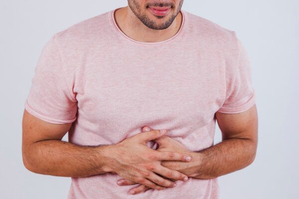 Uomo con mal di stomaco dovuto al consumo di cibi non raccomandati.