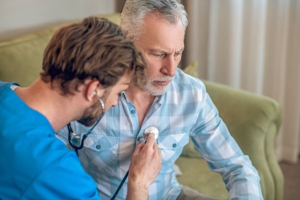 Medico esperto concentrato che esegue l'auscultazione cardiaca per un'aritmia cardiaca