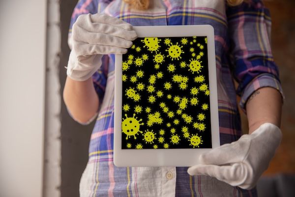 Virus sulle superfici con cui entri in contatto ogni giorno: diffusione del virus, disinfezione. Forma pericolosa di epidemia. Smartphone, laptop, tastiera, tablet, tavolo, pavimento, maniglia della porta. Mani a contatto con oggetti infetti.