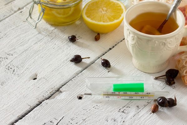 tazza con tè e termometro per abbassare la febbre alta