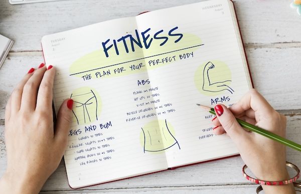 persona che ama il fitness prepara schede per allenamento a circuito