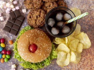 Vista dall'alto di hamburger con aperitivi e un elenco di vari cibi ultra processati