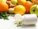 "Integratori alimentari in bottiglie di plastica e prodotti su tavolo bianco per capire a cosa servono vitamine e minerali