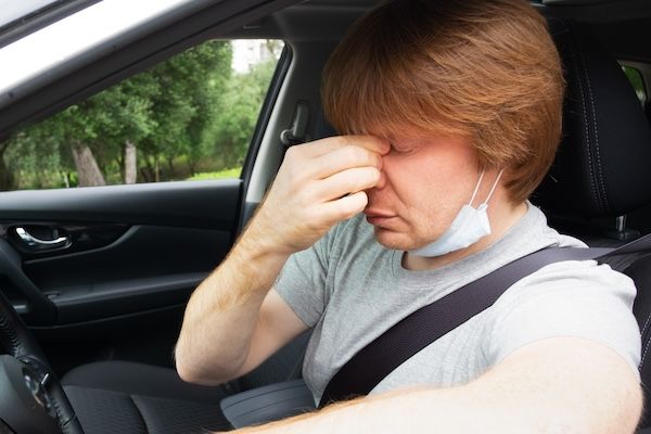 "Autista di automobile assonnato ed esausto si toglie la maschera medica"