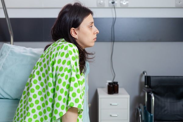 Donna malata di bulimia nervosa ricoverata in ospedale seduta sul letto durante la visita medica