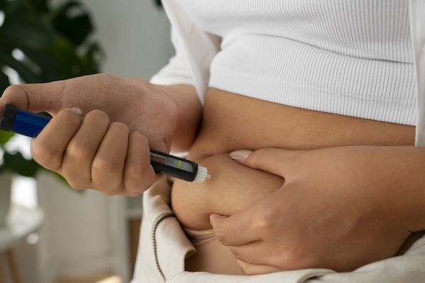 Donna diabetica vista di lato che controlla il suo livello di glucosio e differenza tra diabete 1 e 2