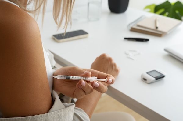 Persona diabetica che controlla fa un'iniezione di insulina per la differenza tra diabete 1 e 2