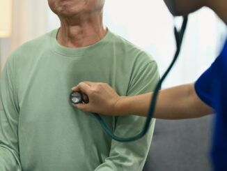 Medico che utilizza uno stetoscopio per ascoltare la respirazione o i battiti cardiaci di un paziente maschio maturo. Concetto di assistenza sanitaria per un paziente con pacemaker