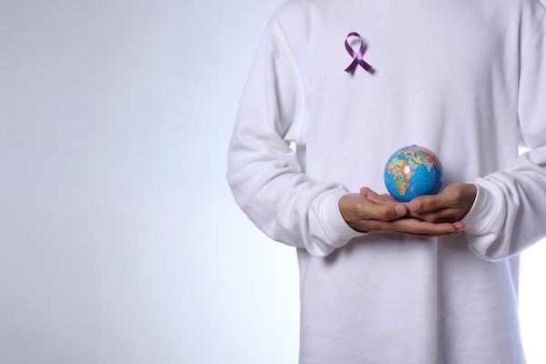 Uomo che tiene un palloncino e indossa un nastro contro il cancro concetto di associazione contro i tumori 