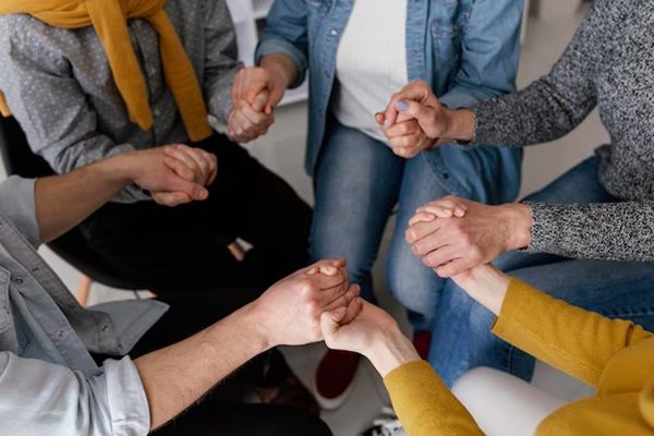 Sessione di terapia di gruppo tenendosi per mano