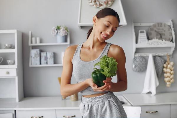 bella-donna-sportiva-che-cucina-verdure