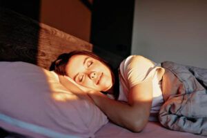 ragazza adorabile e attraente che sorride e dorme felicemente a letto