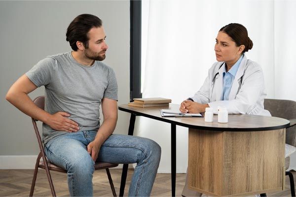 vista-laterale-di-un-uomo-che-soffre-di-dolore-e-consulta-un-medico