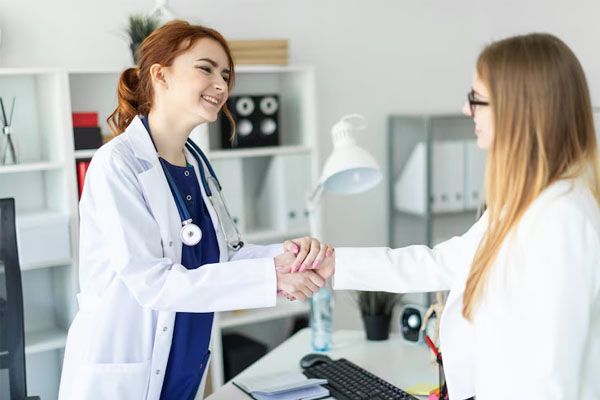 Un medico sorridente accoglie un giovane paziente in ufficio - miglior trapianto capelli Italia