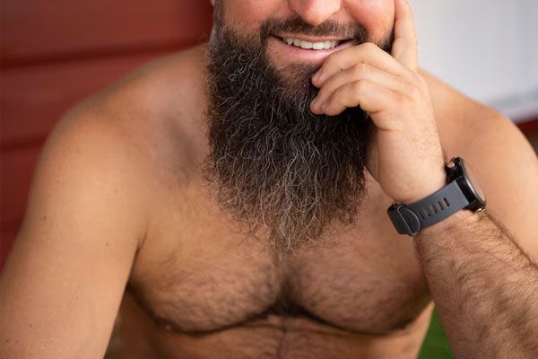 Vista frontale dell'uomo sorridente con molti peli del corpo - Trapianto capillare con peli corporei