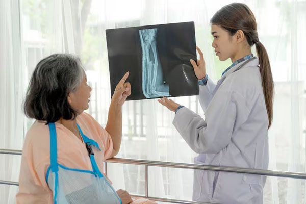 Il medico spiega alla donna con l'aiuto di una lastra radiografica