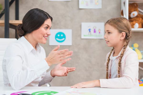 Ritratto sorridente di psicologia e ragazza che parlano in un ufficio - Diagnosi ADHD infanzia