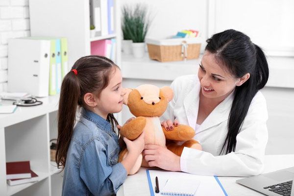 doctora con una niña en su consultorio