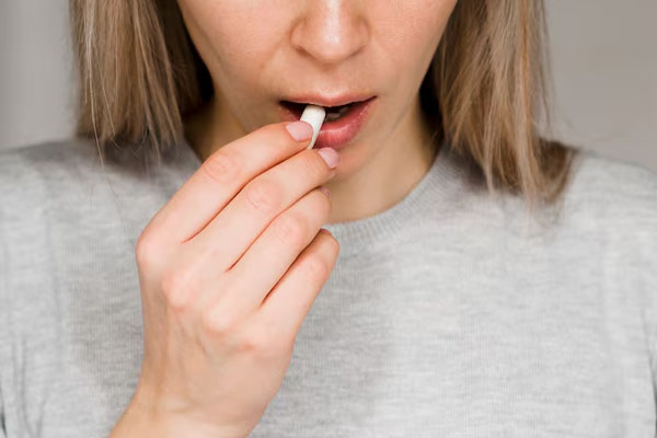 primo piano donna che prende una pillola