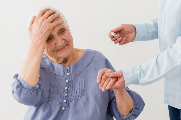Una donna anziana si tocca la fronte mentre il medico le misura la temperatura