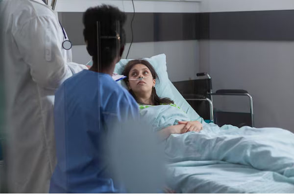 Donna che parla con il medico nel letto d'ospedale