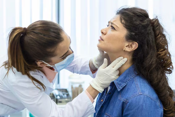 Il medico esamina il collo del paziente con un'espressione preoccupata.