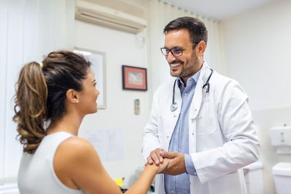 Una donna di spalle alla telecamera parla con il suo medico.