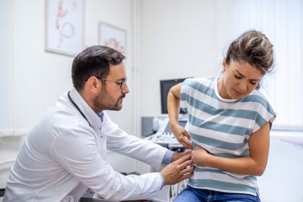 Persona adulta in visita medica per sintomi intestinali