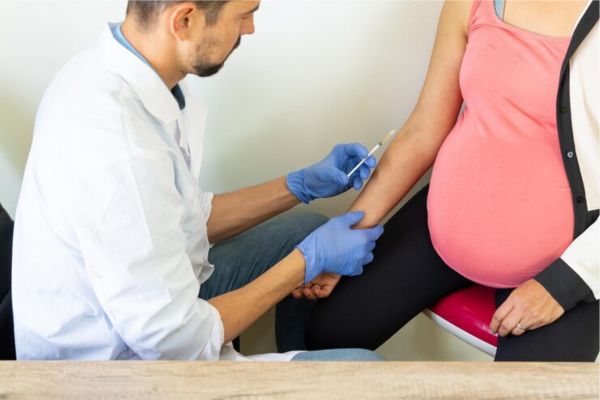 Immagine di una visita medica con analisi del sangue e controllo prenatale.