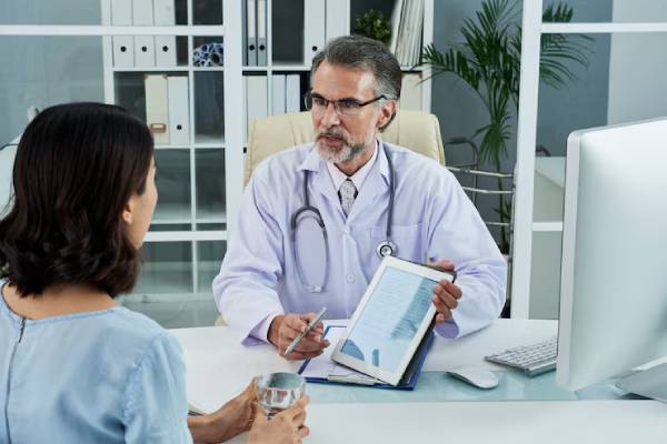 Medico specialista durante una sessione di consulenza genetica con il paziente in studio clinico