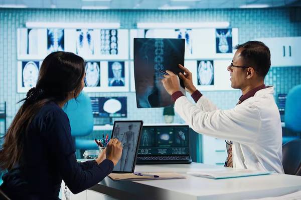 Medico specialista che discute i risultati radiografici con un paziente in uno studio clinico moderno