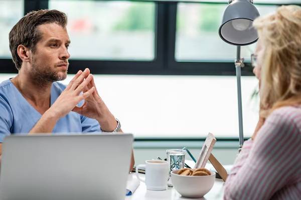 Medico o psicologo che assiste un paziente con interesse ed empatia