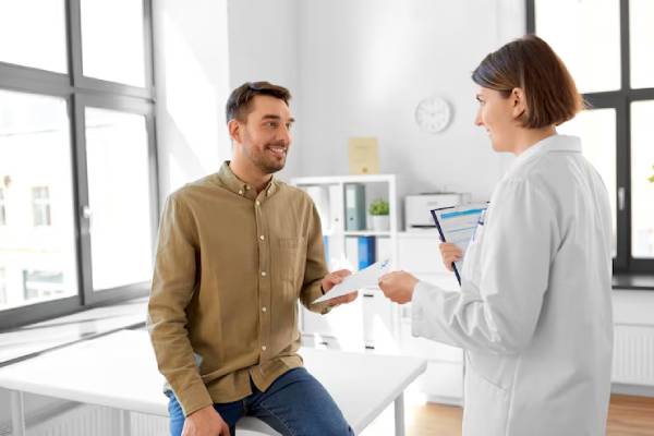 Medico che discute con un paziente sui sintomi e diagnosi dell’orticaria acquagenica